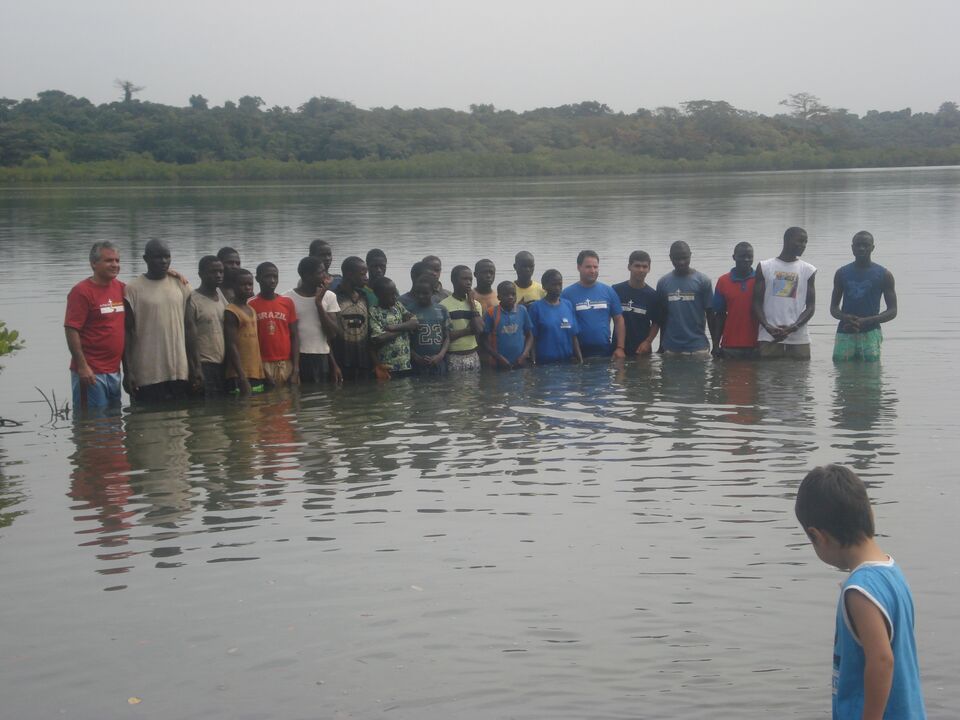 Row of young people standing side by side in the river, at a baptism in Guinea-Bissau