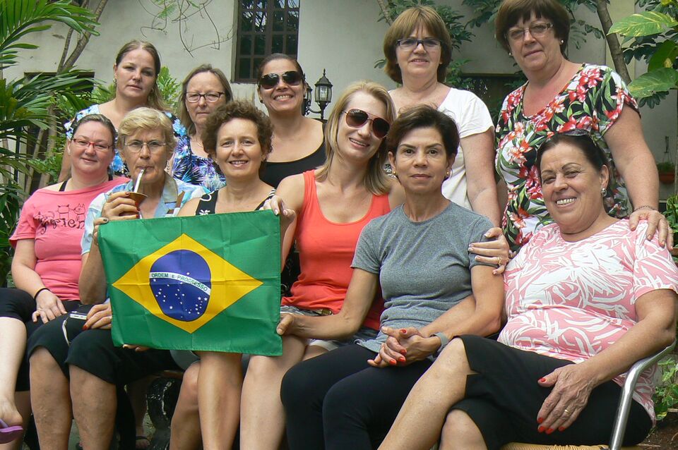 Voluntárias brasileiras com a bandeira do Brasil ao lado de irmãs africanas