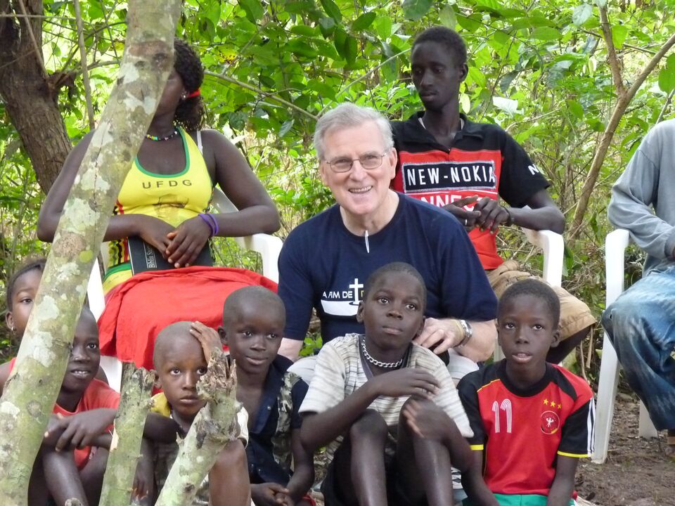 Siegfried Zilz sitting among children in Guinea-Bissau
