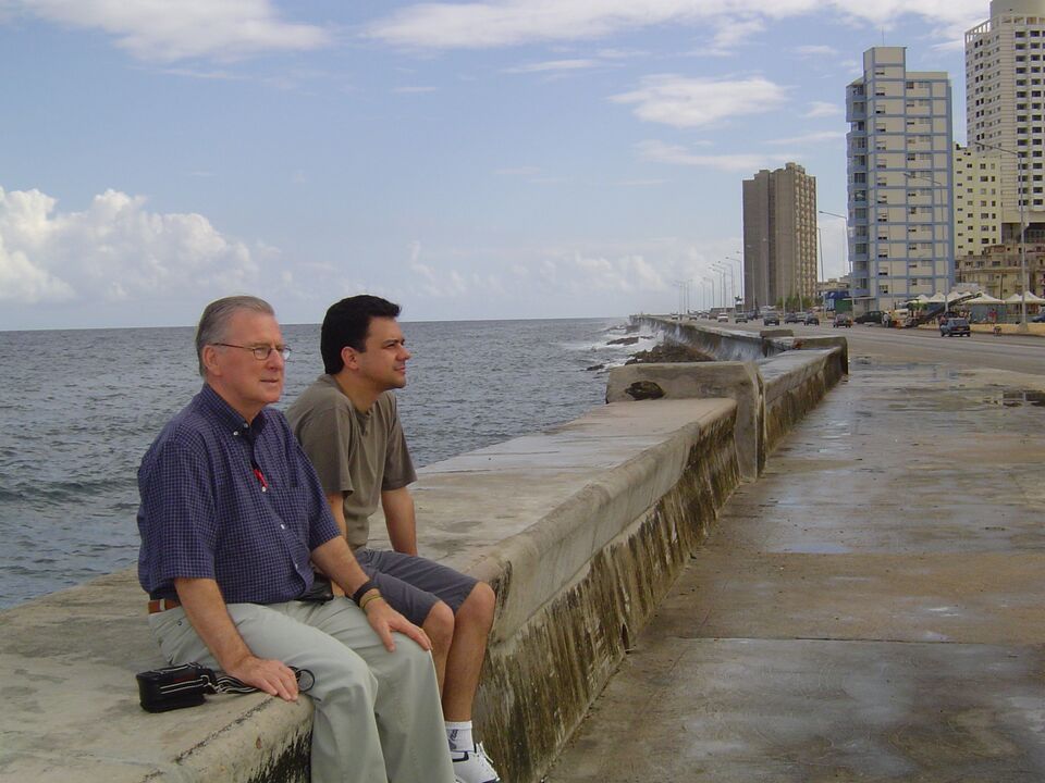 Siegfried Zilz e Alexandre Macedo sentados no muro do Malecón